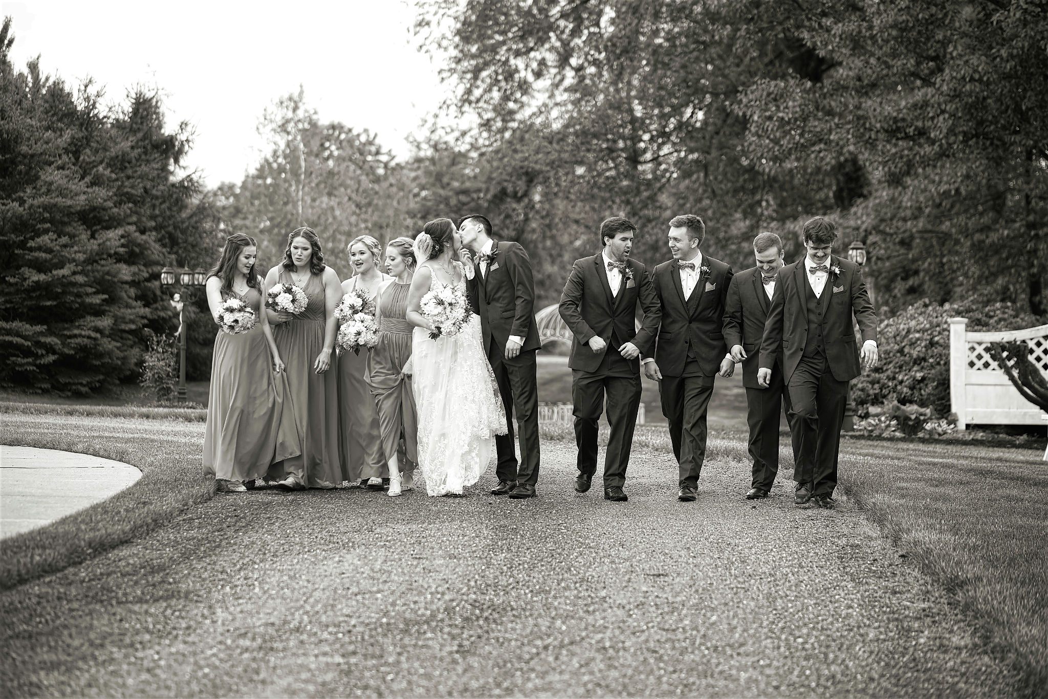 Full wedding party walking — black and white